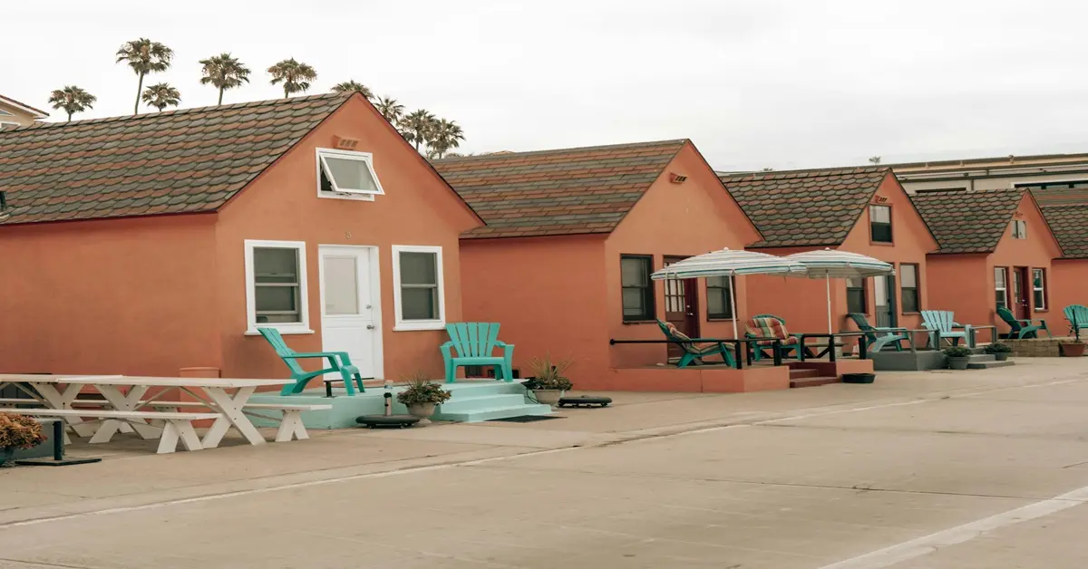 Modern tiny house for sale in the US with deck and trees, showing affordable small-home living